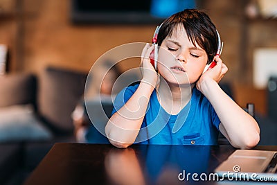 Concentrated little boy listening music in headphones Stock Photo