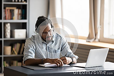 Concentrated biracial guy listening to favorite music while planning workday. Stock Photo