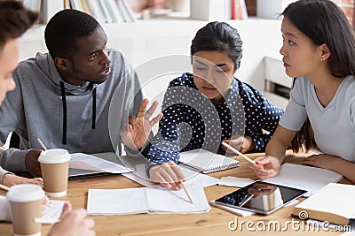 Focused diverse students discuss ideas studying in class together Stock Photo