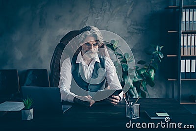 Concentrated pensive strict old man grandfather company owner sit table chair have job interview read attentive Stock Photo