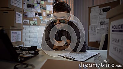 Concentrated policeman thinking over committed crime, ideas of crime proof Stock Photo