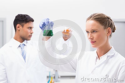 Concentrated scientists holding beakers with fluid Stock Photo