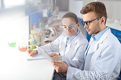 Concentrated scientists using digital tablet during work in laboratory Stock Photo