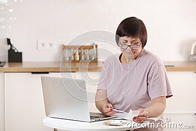 Concentrated senior woman in eyeglasses calculating utility bills or domestic expenditures,doing financial paperwork Stock Photo