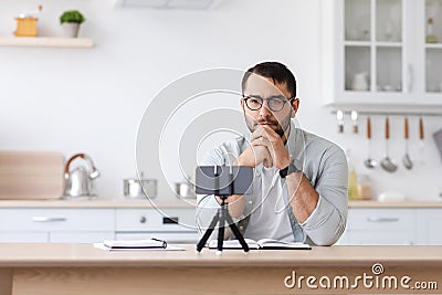Concentrated serious adult caucasian male teacher with beard in glasses watching to phone Stock Photo