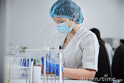 Concentrated serious biochemist in a disposable bouffant cap at work Stock Photo