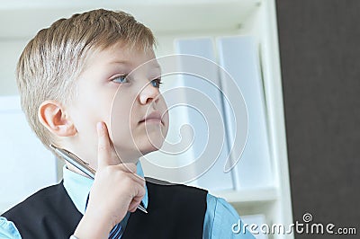 Concentrated small boy in suit thinking about money and budget increasing ways. Little financial director. Stock Photo