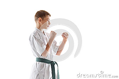 Concentrated teen boy, in defensive karate stance, showcasing focus and readiness, practicing isolated on white studio Stock Photo