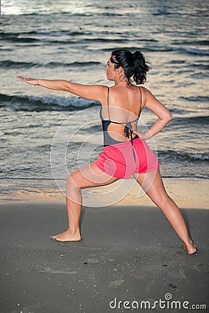 Concentrated woman makes yoga exercises Stock Photo