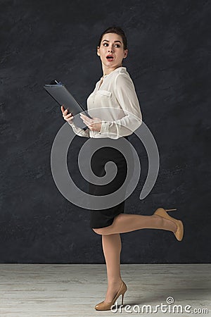 Concentrated woman with tablet on gray background Stock Photo