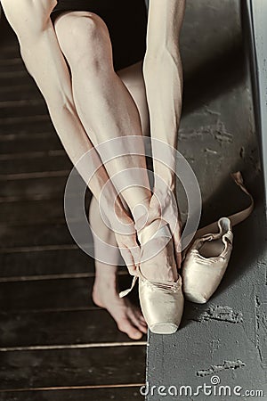 Concentrated woman wearing her ballet shoes in the studio Stock Photo