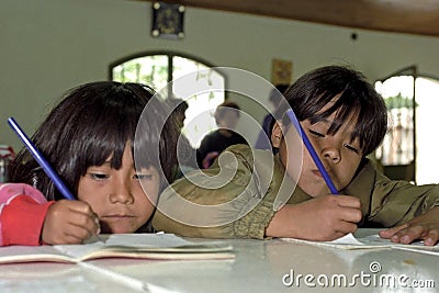 Concentrated writing girls in schoolhouse Editorial Stock Photo