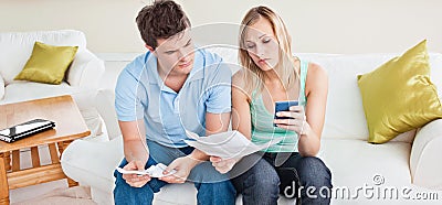 Concentrated young couple calculating bills Stock Photo