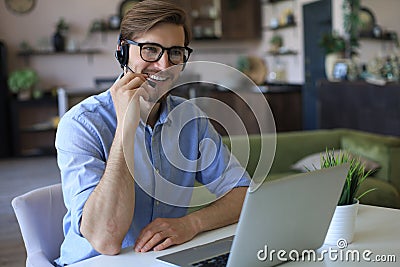 Concentrated young freelancer businessman using laptop for video conferance, working remotely online at home Stock Photo
