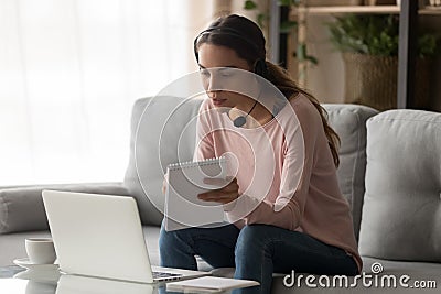 Concentrated young lady wearing headset attending educational webinar online. Stock Photo