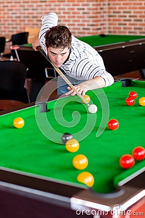 Concentrated young man playing snooker Stock Photo