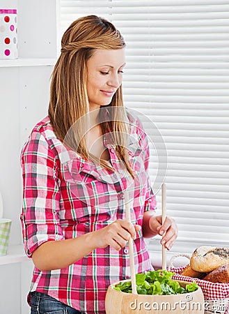 Concentrated young woman preparing a salad Stock Photo