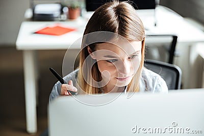 Concentrated young woman work in office using computer Stock Photo