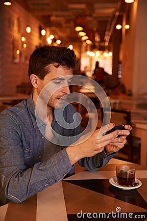 Concentrating millenial texting in a restaurant Stock Photo