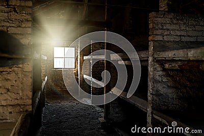 Concentration death camp dark eerie wooden bunk bed barracks with light rays shining through window. Extermination camp sleeping Editorial Stock Photo