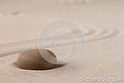 Concentration trough focus on a zen meditation stone. Round rock in sand texture background Stock Photo