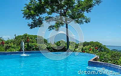 Concepcion volcano view from pool, surrounded by nature, red flowers Stock Photo