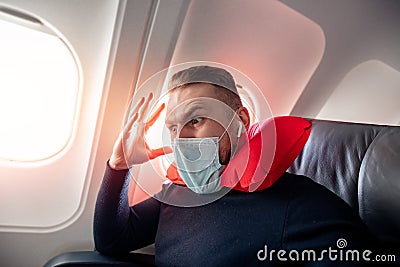 Concept aerophobia or aviophobia. Afraid of fear flying on airplane and height tourist man in safe medical mask Stock Photo