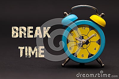 Concept,alarm clock with break time phrase written on black back Stock Photo