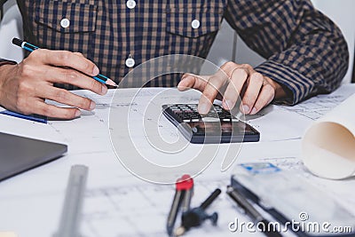 Concept architects, Hand of asian young man engineer using calculator for calculation number of structural materials architects On Stock Photo