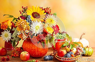 Concept of autumn festive decoration for Thanksgiving day. Autumn bouquet of flowers and berries in a pumpkin on a table, Stock Photo