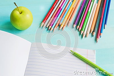 Concept back to school.School accessories, colored pencils, pen with empty notebook on blue wooden background Stock Photo