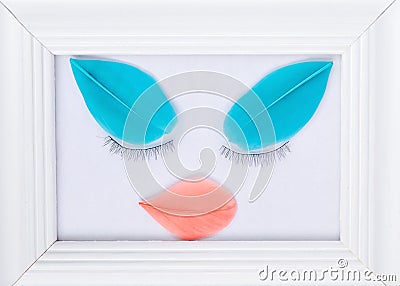 The concept of beauty : white photo frame decorated by the beauty of your eyelashes and feathers in mint and coral colors on a Stock Photo