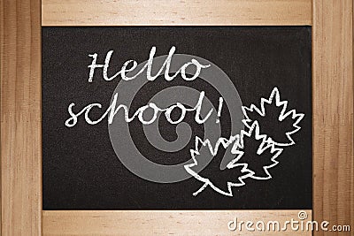 The concept of the beginning of the school year. On the black black blackboard in chalk is written Hello School Stock Photo
