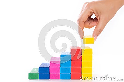 Concept of building success foundation. Women hand put wooden blocks in the shape of a staircase Stock Photo