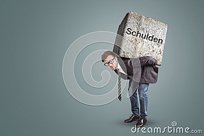 Businessman bending under a heavy stone with the German word `Schulden` written on it Stock Photo