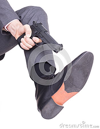 Businessman shooting himself in the foot with a handgun Stock Photo