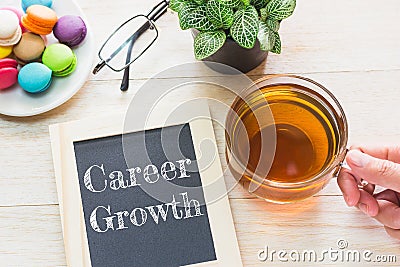 Concept Career Growth message on wood boards. Macaroons and glass Tea on table. Stock Photo