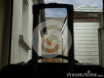 Concept cheap travel accommodation, Ugly view through the window, Travel case out of focus in foreground Stock Photo