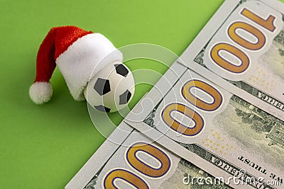 The concept of Christmas football victory or defeat. New Year sports betting or gift. Toy soccer ball in a red Santa Claus hat Stock Photo