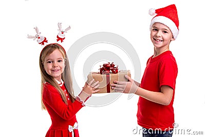 Concept: Christmas or Happy New Year holiday. Happy boy with santa hat on his head and a girl with deer horns, holding Stock Photo