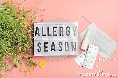 The concept combating preventing seasonal allergies. Fresh flowers medical mask pills drops medicine pink background. Stock Photo