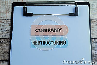 Concept of Company Restructuring write on sticky notes isolated on Wooden Table Stock Photo