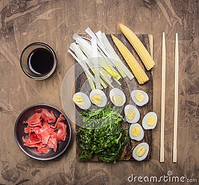 Concept cooking Chinese food, boiled quail eggs with seaweed Chuka, and corn wooden rustic background top view Stock Photo