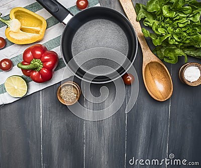 Concept cooking veggie food, lettuce cookie, cherry tomatoes, bell peppers, lime, seasonings, wooden spoon, lined around a black p Stock Photo