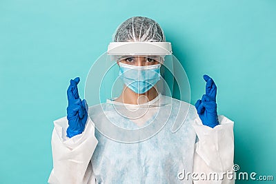 Concept of coronavirus, healthcare and quarantine. Close-up of hopeful female doctor in personal protective equipment Stock Photo