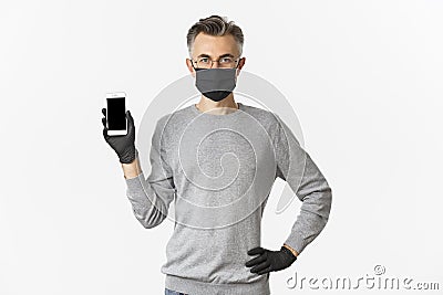 Concept of covid-19, social distancing and lifestyle. Image of confident middle-aged man in glasses, medical mask and Stock Photo