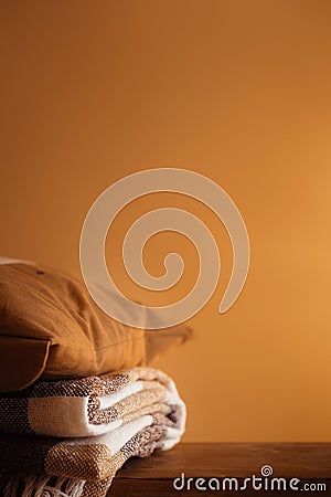 concept of coziness, comfort and warmth at home. stack of wool textile fluffy blanket plaid in interior Stock Photo