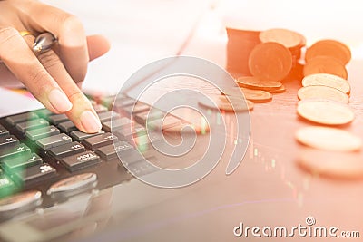 Concept of currency trading. Stack of coins and a hand holding is examining a technical chart of financial instrument Stock Photo