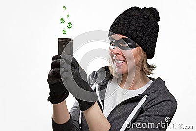 The concept of cybercrime and hacking. Portrait of a woman in a black hat, gloves and mask, who is holding a mobile phone. Dollar Stock Photo