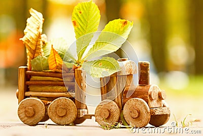 Concept design autumnal mood, yellow foliage on a background and a toy train. Fall October or November. Stock Photo